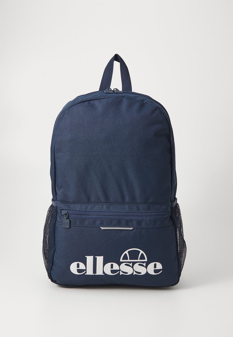 Sac à dos bleu marine avec une poche avant zippée, des poches latérales en mesh, une poignée supérieure et un logo blanc "ellesse" sur la poche avant.