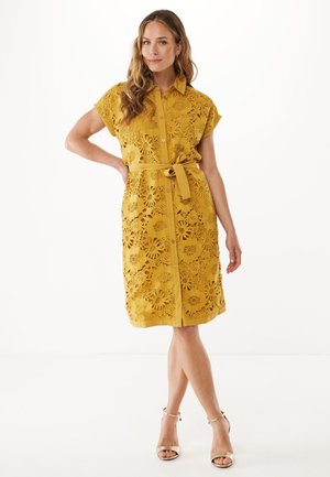 Gelbes Spitzenkleid mit floralen Ausschnitten, Knopfverschluss, Kragen und einem passenden Gürtel. Kurzärmeliges und knielanges Design.