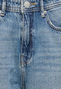 Jeans in denim azzurro chiaro con una finitura sbiadita, caratterizzati da una chiusura con bottone, tasche cucite e dettagli di cucitura a contrasto.