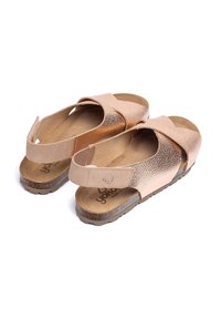 Bronzen leren sandalen met een kruisriemontwerp, een gestructureerd oppervlak, een gewatteerde voetbed en een stevige rubberen buitenzool. Klittenband om de enkel voor aanpassing.