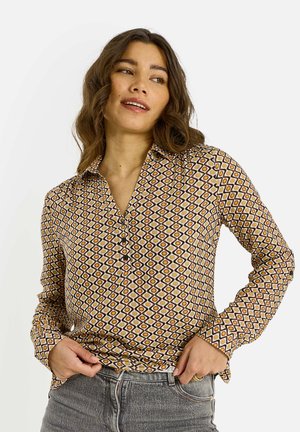 Camisa abotonada con un estampado geométrico en marrón, amarillo y blanco. Mangas largas con cuello, fabricada en una tela ligera.