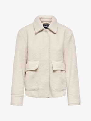 Veste texturée de couleur crème avec un col, deux poches avant et une coupe droite. Présente un tissu doux et duveteux pour plus de chaleur.