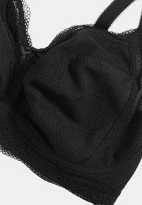 Black mesh bralette featuring a soft, textured fabric, decorative lace trim, and adjustable straps, designed for comfort and breathability.