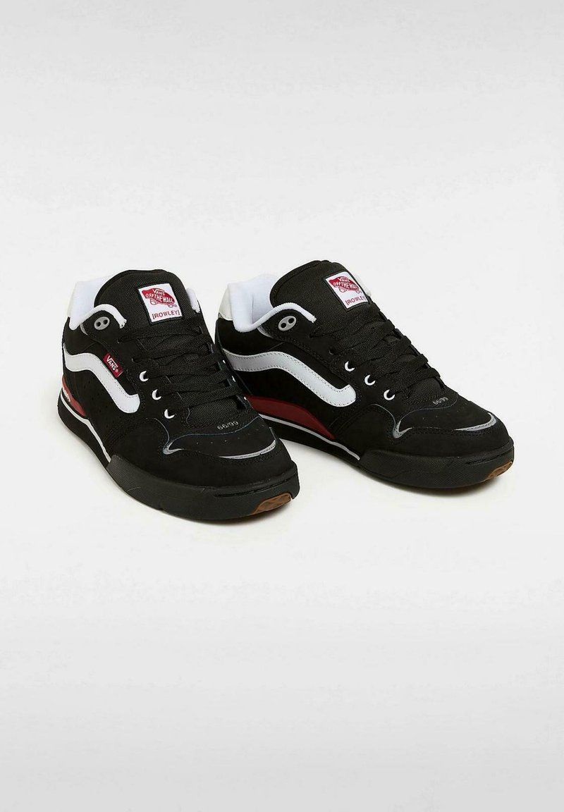 Zwarte sneaker met witte en rode accenten. Bovenwerk van suede, gevoerd kraagje en zwarte rubberen zool. Kenmerkt een klassiek zijkleurpatroon.