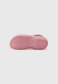 Pink rubber shoe sole with textured tread patterns and branded accents. Features a smooth finish and contoured shape for comfort.