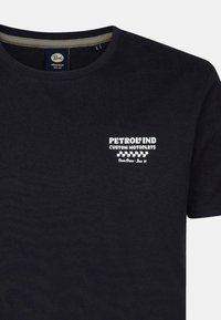 Černé bavlněné tričko s krátkým rukávem, s bílým logem "PETROL IND CUSTOM MOTOPARTS" na levém prsu. Měkká textura, doporučený kulatý výstřih.