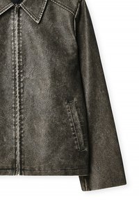 Giacca in ecopelle marrone con texture, collo a punte, chiusura frontale con cerniera e tasche laterali, caratterizzata da una superficie liscia e finitura opaca.