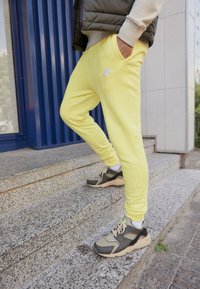 Nike Sportswear CLUB JGGR - Tracksuit bottoms - yellow strike