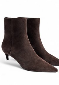 Botas de tobillo de ante marrón con puntera afilada, que cuentan con un tacón bajo tipo kitten y una textura suave, diseñadas para una apariencia elegante.