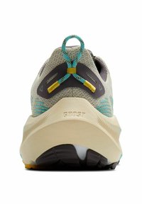 Ljusgrått träningsskor med turkosa och gula accenter, en strukturerad ovandel och en dämpad sula. Har en ögla vid hälen och logotyp på sidan.