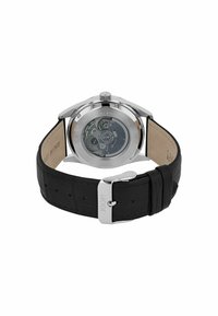 Edelstahl-Uhr mit einem schwarzen, krokodilmustergeprägten Lederarmband, transparentem Gehäuseboden, der das Uhrwerk sichtbar macht, und einer silberfarbigen Schnalle.