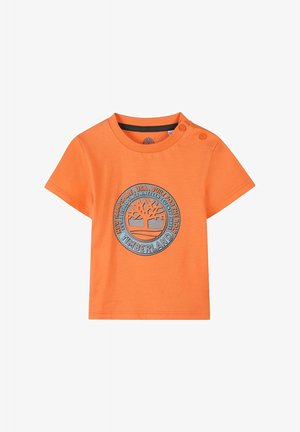 T-shirt arancione in cotone con maniche corte, caratterizzato da una grafica circolare del logo blu Timberland sul davanti e due dettagli a bottone sulla spalla.