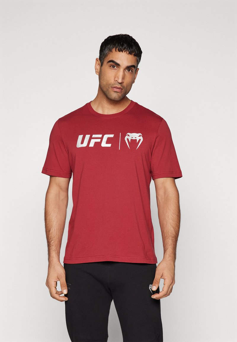Rød bomull t-skjorte med sølv "UFC" logo og et grafisk motiv av en slange på forsetet; korte ermer og rund hals.