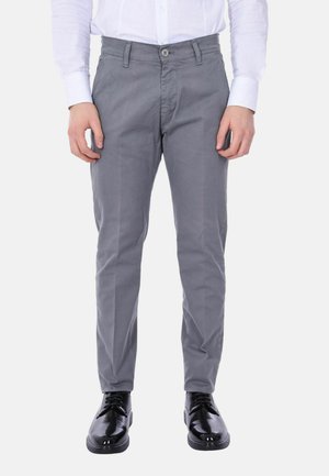 Chinos in cotone grigi con vestibilità slim, dotati di chiusura a bottone, tasche laterali e una texture liscia, abbinati a scarpe nere lucide.