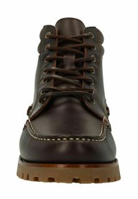 Botte en cuir marron avec une texture lisse, bout rond, œillets en métal et coutures contrastantes en tan. Semelle en caoutchouc robuste avec adhérence.