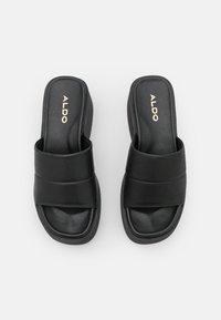 Sandalias negras de playa con dos correas anchas, suela gruesa, textura suave y logo en relieve en la plantilla.