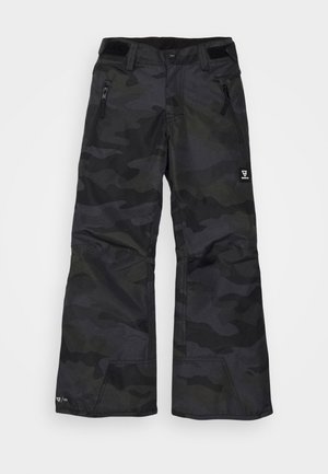 Pantalon camouflage noir en tissu texturé, avec une coupe à jambes larges, des poches latérales zippées et un écusson logo sur la partie inférieure de la jambe.