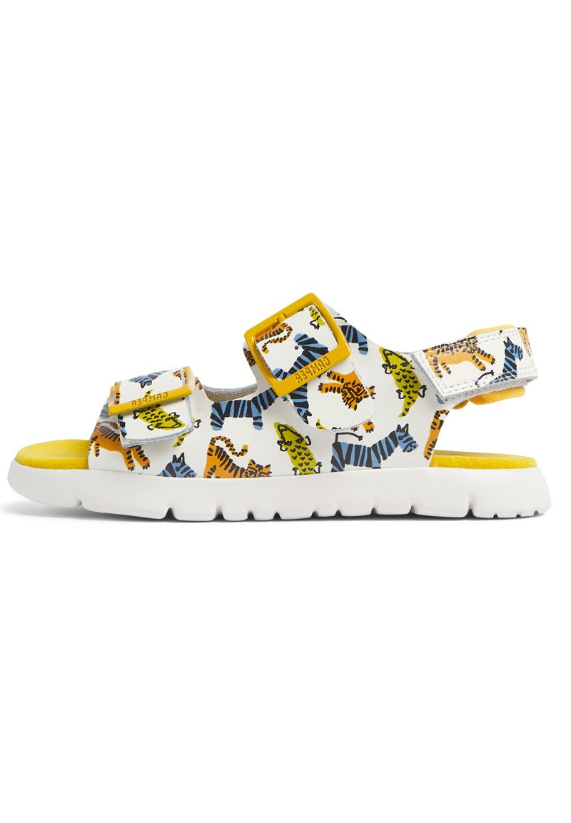 White sandals with a tiger print in orange, green, and blue. Features two adjustable yellow buckles and a cushioned yellow footbed.