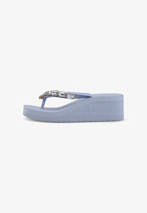 Sandalia tipo flip-flop con cuña en color violeta claro con grandes gemas rectangulares transparentes en las correas y suela texturizada.
