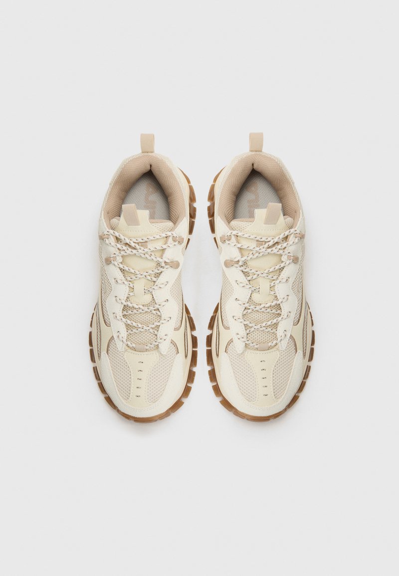 Beige Mesh-Sneaker mit strukturierten Überzügen, ausgestattet mit hellbraunen Gummisohlen und Schnürsenkeln, die kunstvoll mit reflektierenden Fäden verwoben sind.