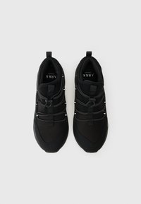 Μαύρα αθλητικά παπούτσια με λείο ύφασμα στο πάνω μέρος, ελαστικά κορδόνια τύπου bungee και υφασμάτινη σόλα από καουτσούκ για πρόσφυση.