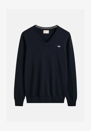 Tummansininen V-pääntie villapaita, joka on valmistettu pehmeästä kankaasta, pitkät hihat ja ribbauskaulus. Rinnassa on pieni GANT-logo.