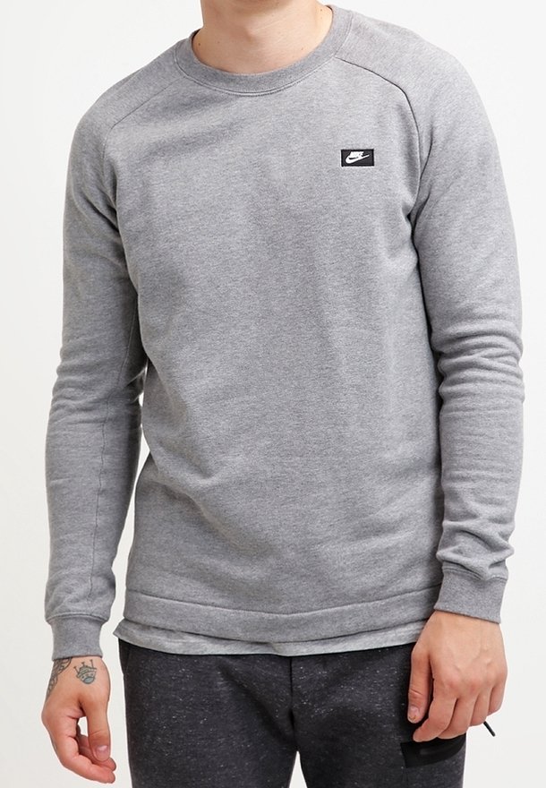 Grijze sweatshirt gemaakt van zachte stof, met een ronde hals, lange mouwen en een klein zwart Nike-logo op de linker borst. Glad textuur.