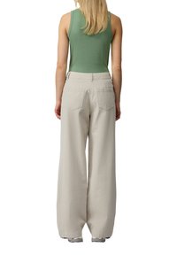 Lichtgrijze wijde broek met hoge taille, gemaakt van katoen, en achterzakken, gecombineerd met een aansluitend groen geribbeld tanktop.