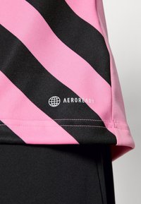 Maglietta a maniche corte con strisce diagonali rosa e nere, con il marchio AEROREADY in bianco sull'orlo, realizzata in materiale tecnico liscio.