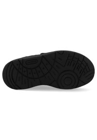 Fekete sneaker talp, melyen texturált gumi felület található, különböző barázdázott mintázatokkal és a "LACOSTE" logóval, amely bele van nyomva.