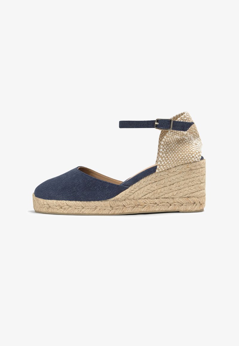 Chaussure espadrille compensée avec tige en tissu bleu marine, bride à la cheville avec boucle, talon beige tressé et semelle plateau en jute tressé.