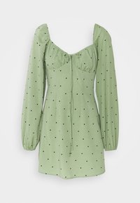 Vihreä mekko, joka on valmistettu pehmeästä kankaasta mustilla pilkuilla, ja jossa on puffihihat, neliönmuotoinen pääntie sekä solmimis-yksityiskohta edessä.