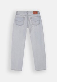 Light blue denim jeans with a straight leg design, featuring two back pockets and a brown logo patch at the waistband.