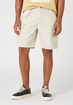 Pantaloni cargo beige con più tasche, vestibilità rilassata e gamba dritta. Realizzati in tessuto leggero, adatti per il clima caldo.