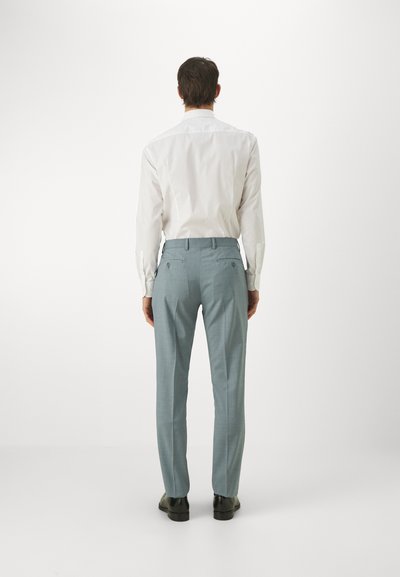 Pantaloni bărbați ajustați de culoare albastru deschis, cu o textură netedă, două buzunare la spate și șnururi pentru curea, asortați cu o cămașă albă cu mâneci lungi.