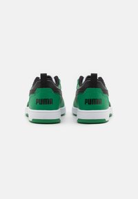 Sneakers verde e neri con una texture liscia, suola bianca e un prominente marchio "PUMA" sul tallone. Presentano una linguetta per il supporto.