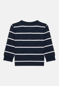 Maglia a maniche lunghe blu navy con strisce orizzontali bianche. Presenta un collo rotondo e polsini a costine, realizzata in morbido cotone.