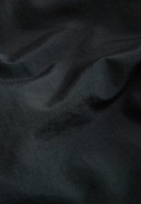 Crni materijal s glatkom, blago teksturiranom površinom, s suptilnim nabora i uniformnom bojom s minimalnim varijacijama.