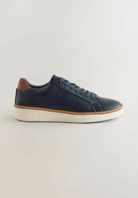 Sneaker in pelle blu navy con un accento in pelle marrone sul tallone, suola in gomma bianca e punta rotonda. Presenta lacci in tono e dettagli cuciti.
