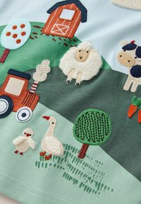 Cămașă brodată pentru copii, cu o scenă de fermă ce include un hambar roșu, oi, vacă, tractor, copac și diverse animale pe un fundal pastel.