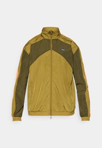 Olivengrønn zip-up jakke med oransje detaljer, med høy krage, elastiske mansjetter og lett, strukturert stoff. Under Armour-logo synlig.