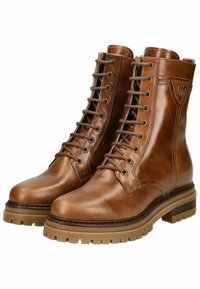 Bottes en cuir marron à lacets avec un bout rond, des détails de couture et une semelle en caoutchouc à profil prononcé. Présente une tige haute et des œillets en métal.