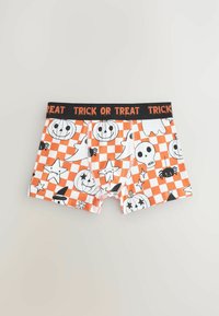 Pomarańczowe i białe szorty chłopięce w kratkę z różnymi wzorami związanymi z Halloween, w tym dyniami, duchami, gwiazdami i czaszką. Czarny pas z napisem "TRICK OR TREAT".