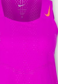 Canotta sportiva Nike viola con texture perforata, dotata di un logo arancione sulla spalla e un design in tessuto traspirante.