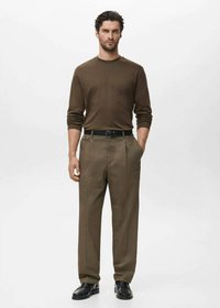 Tamno smeđa košulja dugih rukava u kombinaciji sa svijetlosmeđim plisiranim hlačama i crnim cipelama. Jednostavan dizajn s klasičnim krojem i glatkom teksturom.