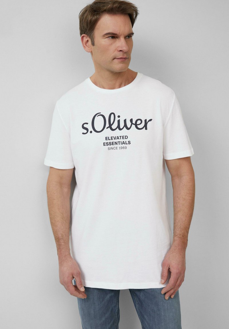 Biała bawełniana koszulka z okrągłym dekoltem i krótkimi rękawami, z czarnym nadrukiem z napisem „s.Oliver Elevated Essentials.”