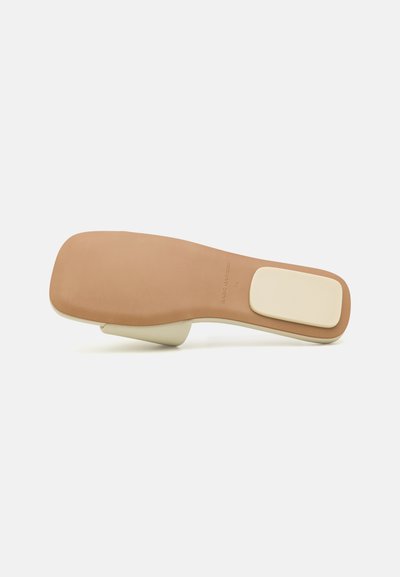 Beige leather shoe insole with a smooth surface, slightly curved shape, rectangular footbed, and a contrasting off-white heel accent.