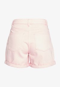 Short en denim rose clair avec ourlets roulés, deux poches arrière et passants de ceinture, vu de dos sur un fond uni.