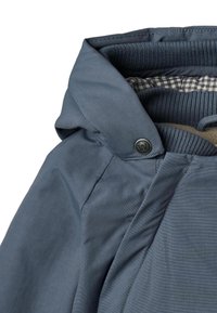 Sininen hupullinen takki, jossa sileä ulkopinta, resoroitu sisäkaulus, ruudullinen vuori ja metallinen nepparikiinnitys.