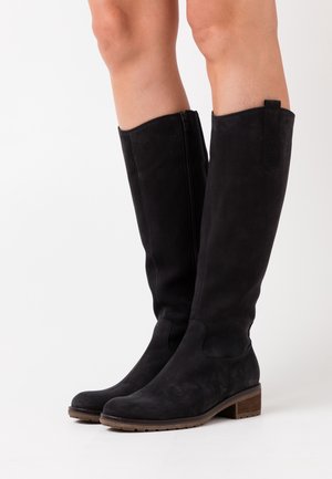 Bottes noires en daim jusqu'aux genoux avec un bout rond, un petit talon empilé et une fermeture éclair sur le côté. Elles présentent une texture lisse et un design minimaliste.